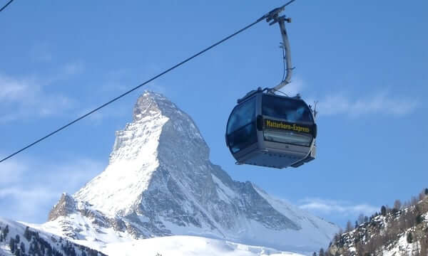 Matterhorn und Seilbahn vor blauem Himmel.