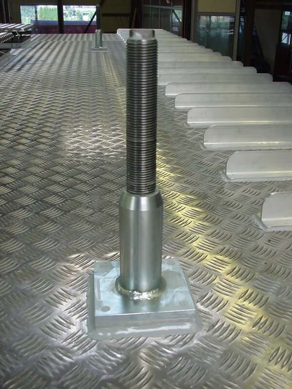 Metallschraube auf geriffeltem Metallboden, industrielles Design.