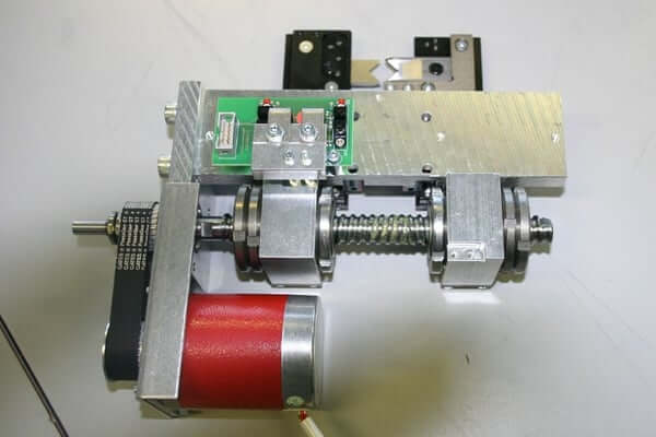 Metallische Maschinenkomponente mit rotem Motor und Platine.