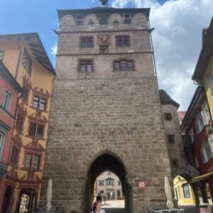 Historisches Stadttor mit umliegenden bunten Häusern.