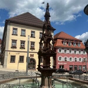 Historischer Brunnen auf deutschem Marktplatz bei Sonnenschein.