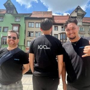 Three men in front of colorful houses in the city.