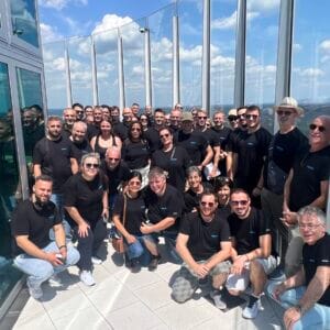 Group of people on a lookout tower in the sunshine.