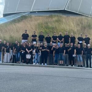 Gruppe von Personen steht draußen vor dem Gebäude.