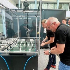 Men play table soccer in a modern building.