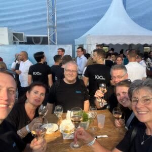 Menschen bei Outdoor-Event stoßen mit Getränken an.