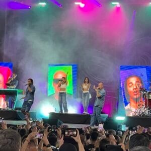 Musikkonzert mit Lichtshow und Live-Band auf Bühne.