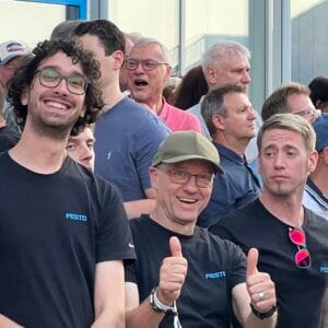 Gruppe von Menschen bei einem Event lächelt fröhlich.