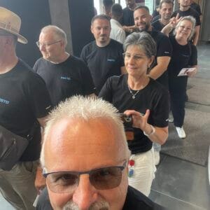 Group of smiling people in black clothing.